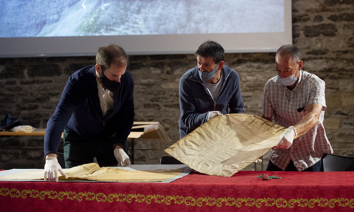 Hiru lagun, 1389an Orreagako ospitaleak eta Zizurkilgo komunitateak sinatutako akordioa biltzen duen pergaminoaren bi puskak batzen. IÑIGO URIZ / FOKU. Hiru lagun, 1389an Orreagako ospitaleak eta Zizurkilgo komunitateak sinatutako akordioa biltzen duen pergaminoaren bi puskak batzen. IÑIGO URIZ / FOKU.