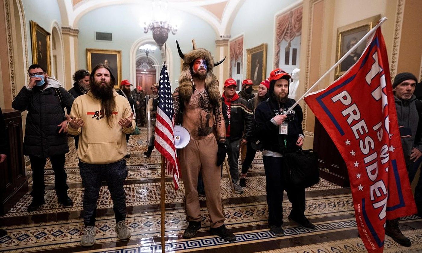 Jacob Albert Chansley Qanon mugimenduko kidea, erdian, Kapitolioa hartu zutenean, urtarrilean. JIM LO SCALZO. Jacob Albert Chansley Qanon mugimenduko kidea, erdian, Kapitolioa hartu zutenean, urtarrilean. JIM LO SCALZO.