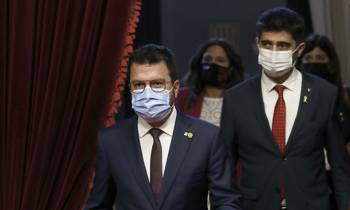 Pere Aragones Kataluniako presidentea eta Jordi Puignero presidenteordea (atzean), atzo, Kataluniako Parlamentuan.. ANDREU DALMAU / EFE. Pere Aragones Kataluniako presidentea eta Jordi Puignero presidenteordea (atzean), atzo, Kataluniako Parlamentuan.. ANDREU DALMAU / EFE.