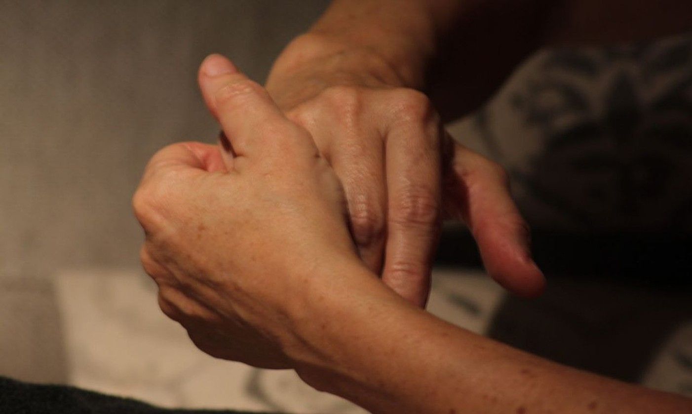 Artritis erreumatoidea duen pertsona bat, eskuetan masajea ematen. OLAIA L. GARAIALDE.