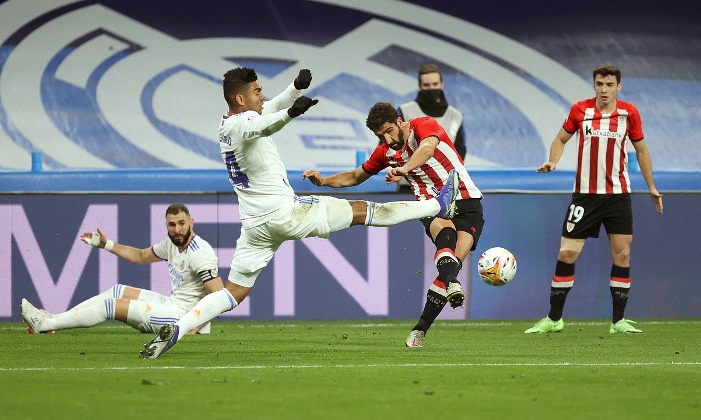 Raul Garcia Atleticeko jokalaria Casemiro Real Madrilekoa gainean duela, atzo, Santiago Bernabeun. KIKO HUESCA / EFE.