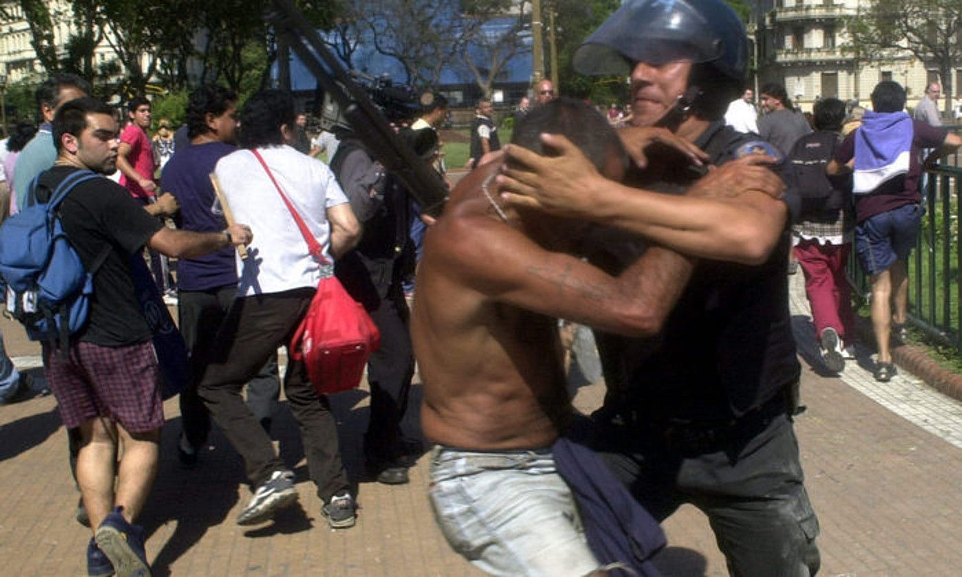 Polizia bat manifestari batekin borrokan, 2001eko abenduaren 20an, Buenos Airesen. MARCELO ARIAS / EFE.