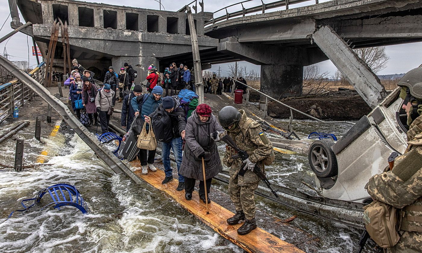 Hainbat zibil Ukrainako armadak eraikitako zubi bat zeharkatzen, gerratik ihesean, Irpinen, Kievetik gertu. ROMAN PILIPEY / EFE.