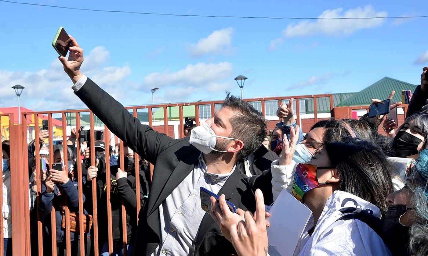 Gabriel Boric gaur Txileko presidente kargua hartuko duena, joan den abenduaren 19an, jarraitzaile batzuekin argazki bat ateratzen. JOSE MIGUEL CARDENAS / EFE.