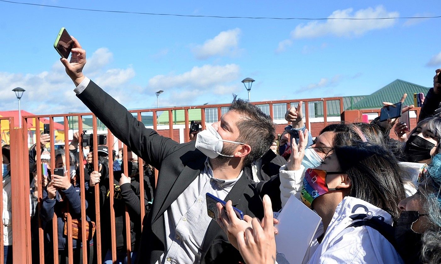 Gabriel Boric gaur Txileko presidente kargua hartuko duena, joan den abenduaren 19an, jarraitzaile batzuekin argazki bat ateratzen. JOSE MIGUEL CARDENAS / EFE.