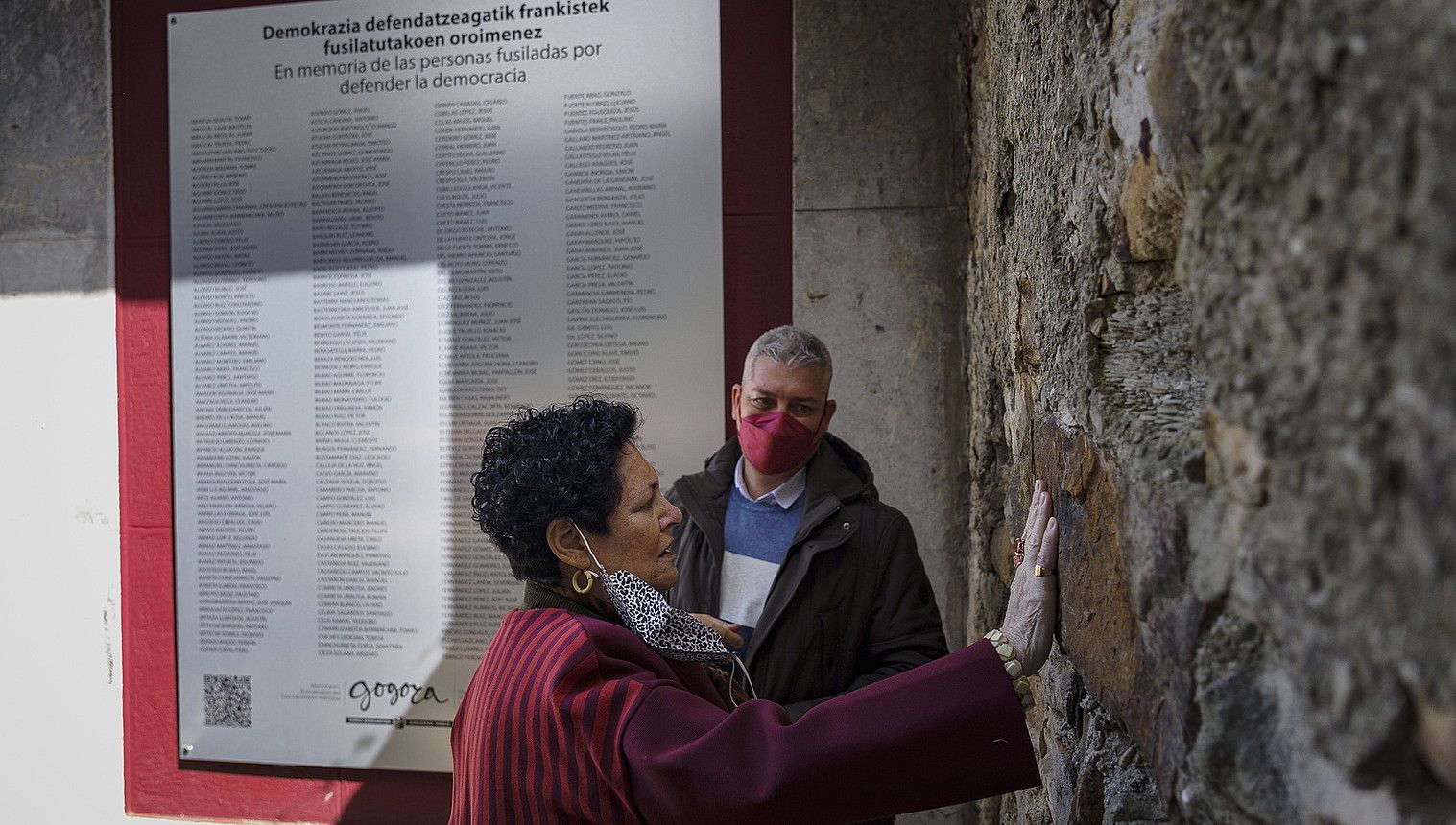 Emakume bat, Derioko hilerrian fusilamenduak egin zituzten hormaren aurrean, atzo inauguratutako plakaren alboan. ARITZ LOIOLA / FOKU.