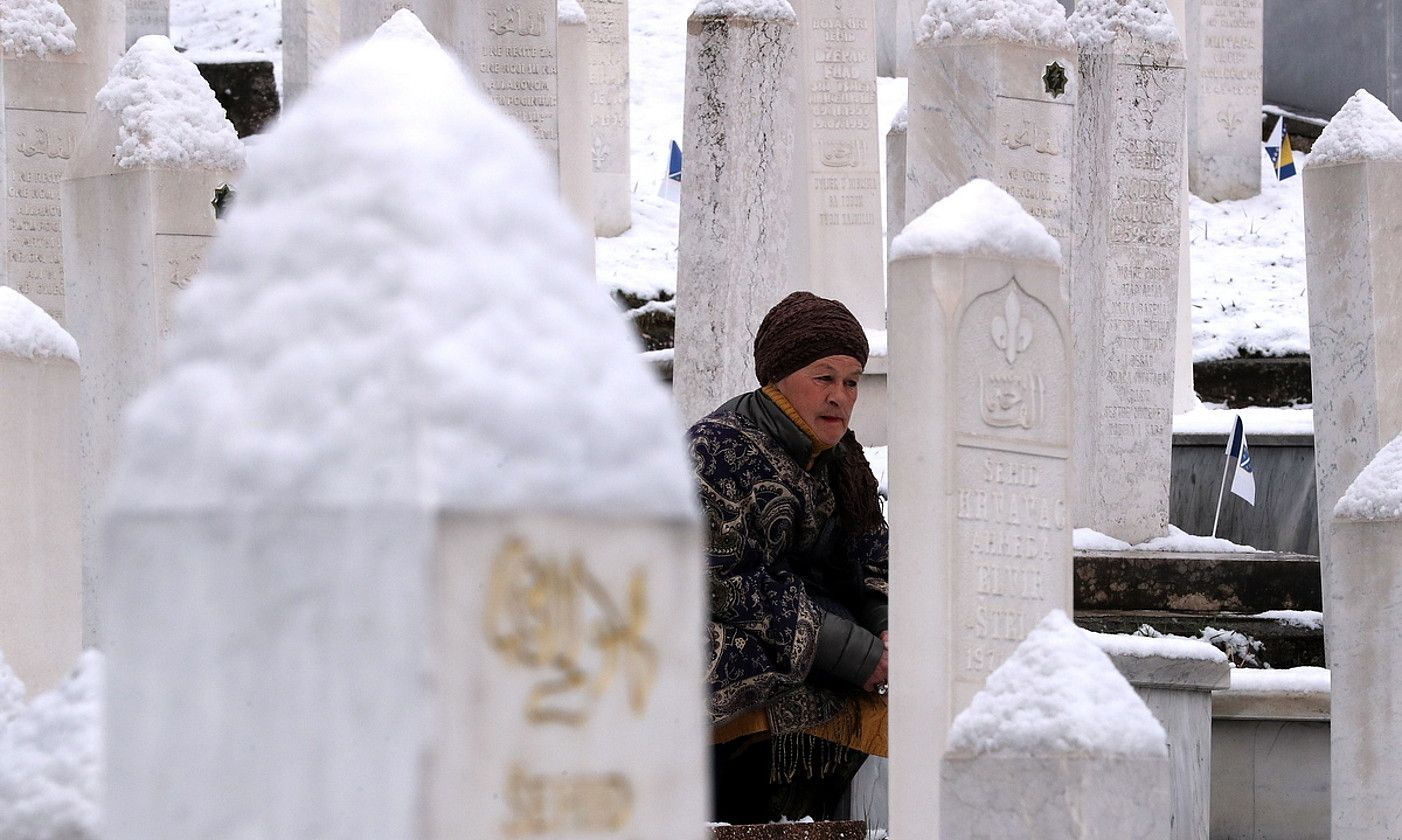 Emakume bat gerran hildakoen hilobi parean otoitzean, Sarajevon. FEHIM DEMIR / EFE.