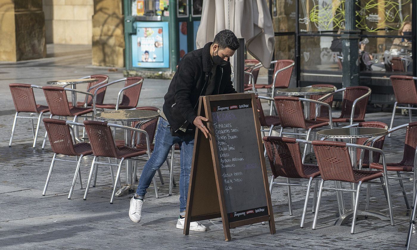 Gazte bat Donostiako ostatu bateko terraza muntatzen. ANDONI CANELLADA / FOKU.