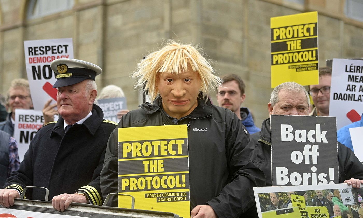 Boris Johnsonen aurkako protesta bat egin zuten, atzo, Belfasten bilerak egin zituzten eraikinaren atarian. M. MARLOW / EFE. Boris Johnsonen aurkako protesta bat egin zuten, atzo, Belfasten bilerak egin zituzten eraikinaren atarian. M. MARLOW / EFE.