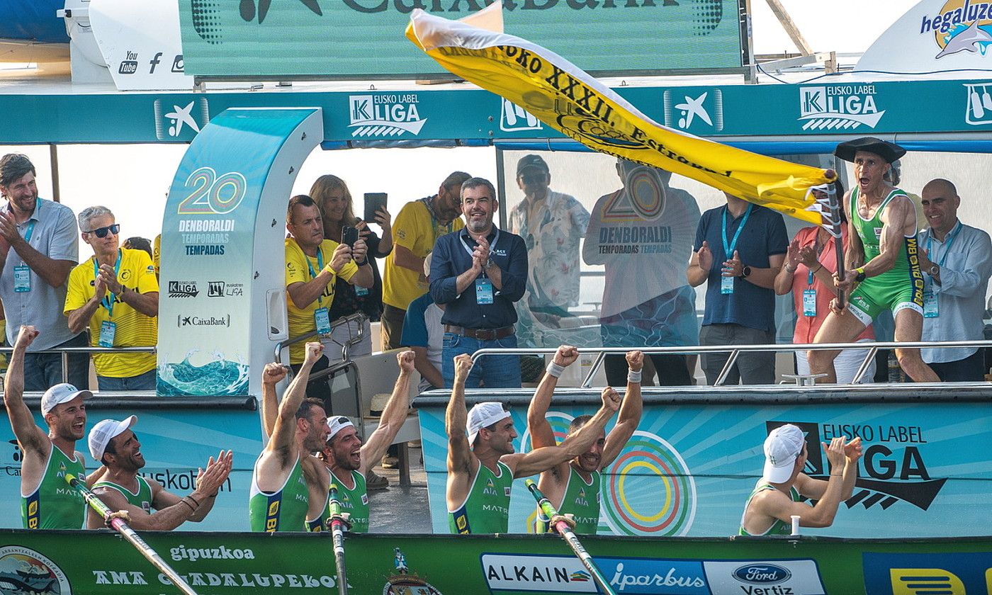 Ioseba Amunarriz Hondarribia taldeko patroia, bandera astintzen, traineruan arraunlariak ospatzen ari direla, atzo, Orion, Eusko Label ligako bosgarren jardunaldian. ANDONI CANELLADA / FOKU.