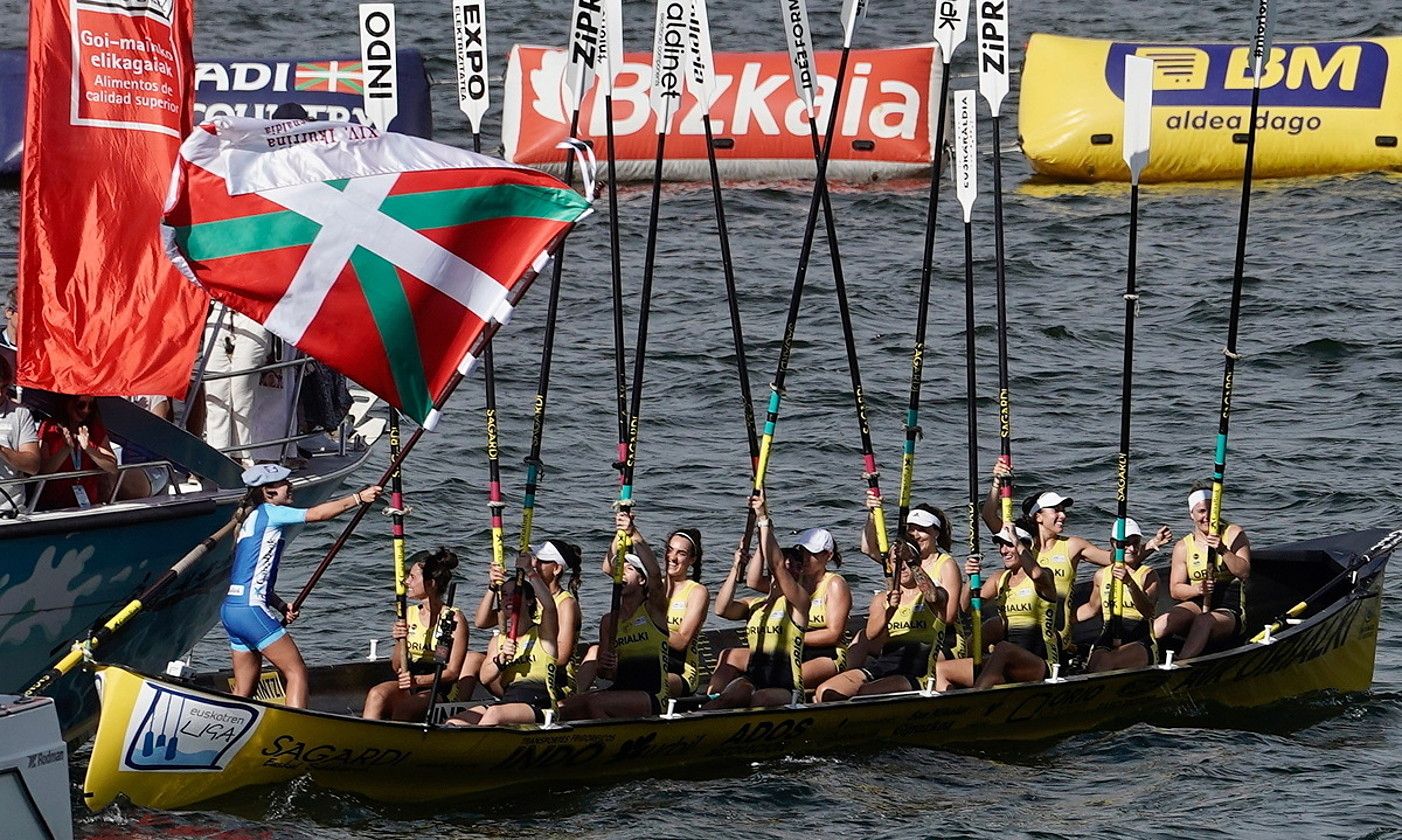 Orioko patroi Nadeth Agirre bandera astintzen, arraunlariek arraunak gorantz dituztela, atzo, Getxon. MARISOL RAMIREZ / FOKU. Orioko patroi Nadeth Agirre bandera astintzen, arraunlariek arraunak gorantz dituztela, atzo, Getxon. MARISOL RAMIREZ / FOKU.