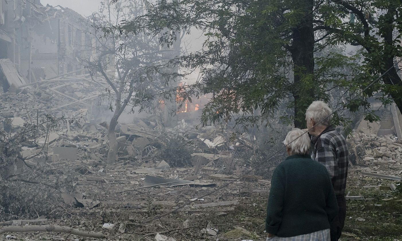 Bi pertsona Errusiak txikitutako eraikin bati begira, uztailean, Kramatorksen, Donetsken. GEORGE IVANTXENKO / EFE. Bi pertsona Errusiak txikitutako eraikin bati begira, uztailean, Kramatorksen, Donetsken. GEORGE IVANTXENKO / EFE.