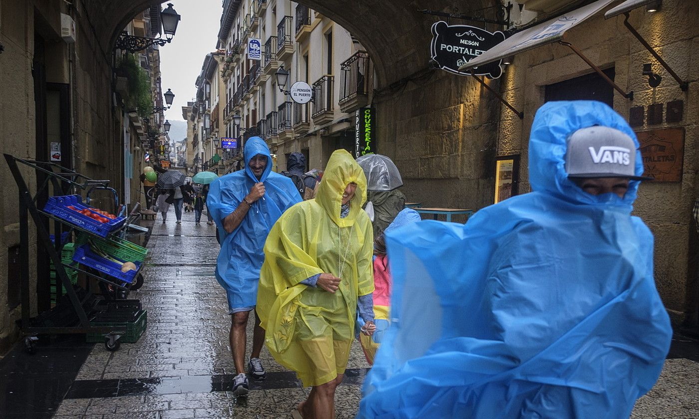Turistek euriari eta haize bolada bortitzei egin behar izan zieten aurre atzo. JON URBE / FOKU. Turistek euriari eta haize bolada bortitzei egin behar izan zieten aurre atzo. JON URBE / FOKU.