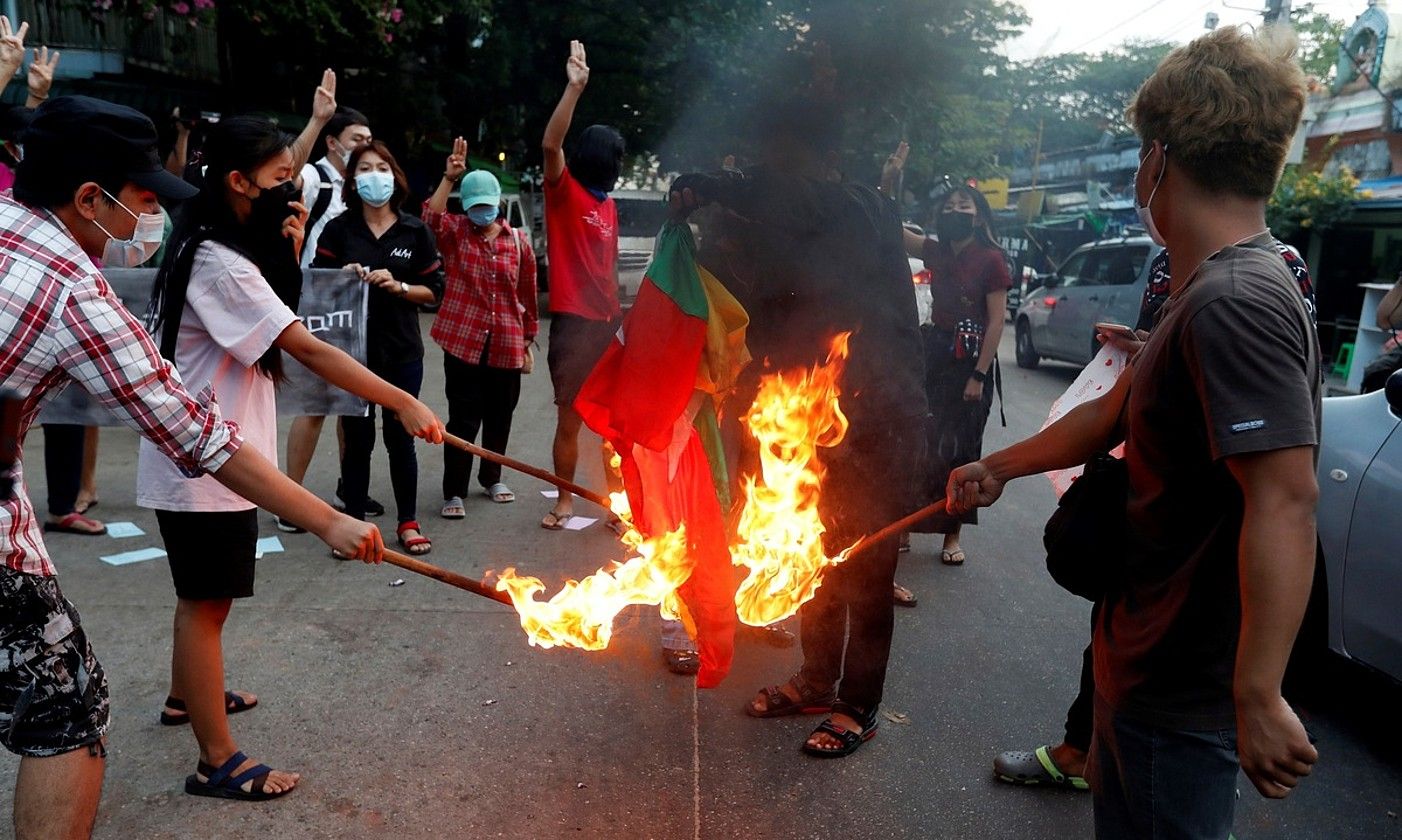 Manifestariak Myanmarko bandera erretzen, iazko azaroan, militarren aurkako protesta batean, Yangonen. EFE.