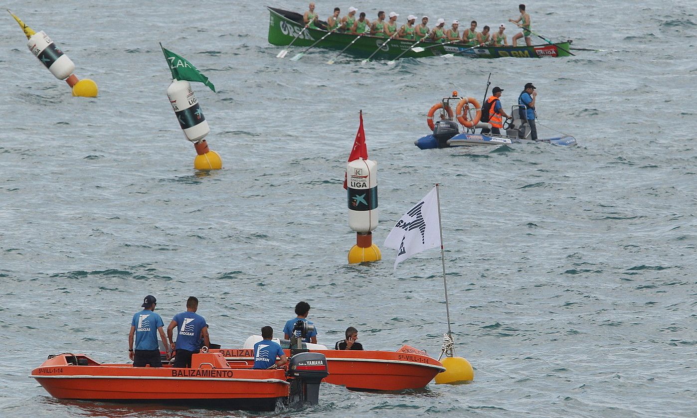 Balizatzaileak ordezko baliza jartzeko lana egin berritan,eta Hondarribia, berotzen, tartean uretako epaileetako bat dela. OSKAR MATXIN EDESA / FOKU.