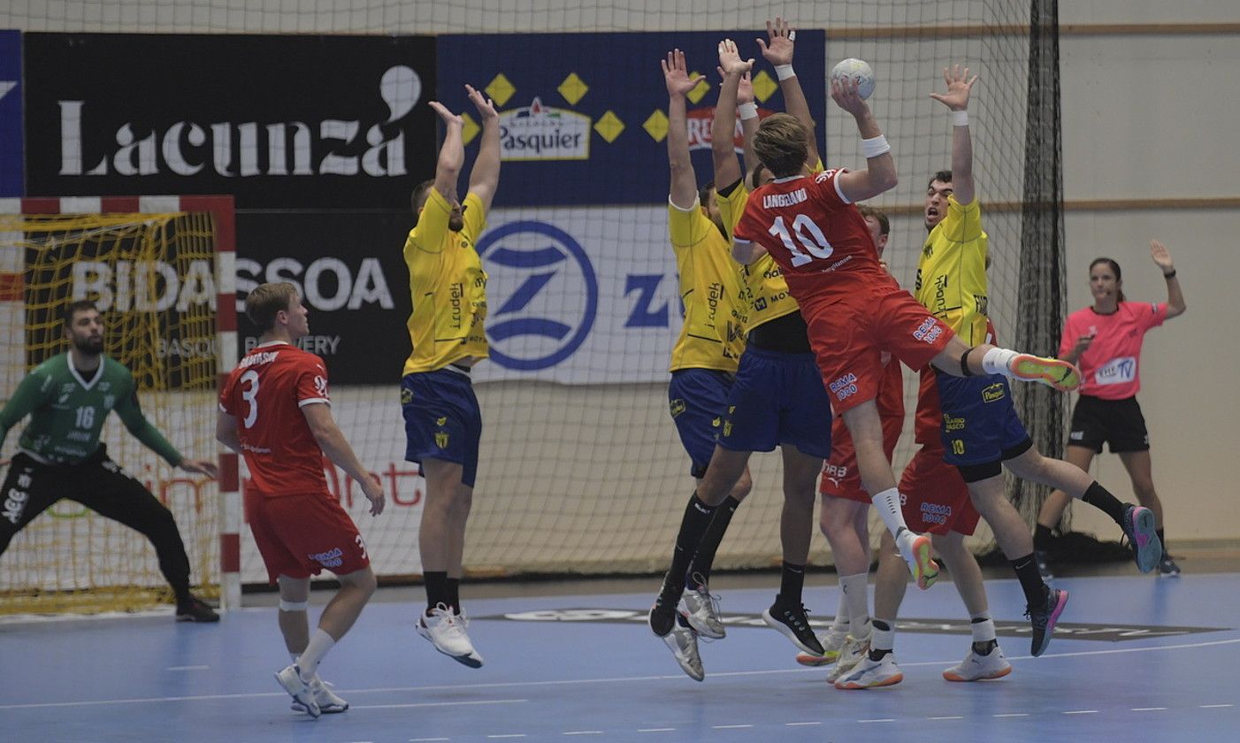 Bidasoako jokalariak, joaneko partidan, Magnus Langelanden jaurtiketa oztopatu nahian . JON URBE / FOKU. Bidasoako jokalariak, joaneko partidan, Magnus Langelanden jaurtiketa oztopatu nahian . JON URBE / FOKU.