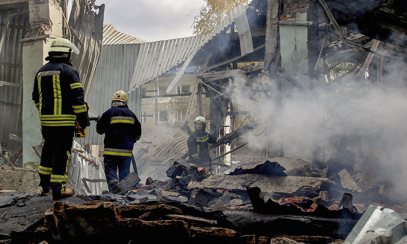 Suhiltzaile batzuk, atzo, bonbardaketa batek Kharkiven (Ukraina) txikitutako lantegi batean lanean. SERGEY KOZLOV / EFE. Suhiltzaile batzuk, atzo, bonbardaketa batek Kharkiven (Ukraina) txikitutako lantegi batean lanean. SERGEY KOZLOV / EFE.
