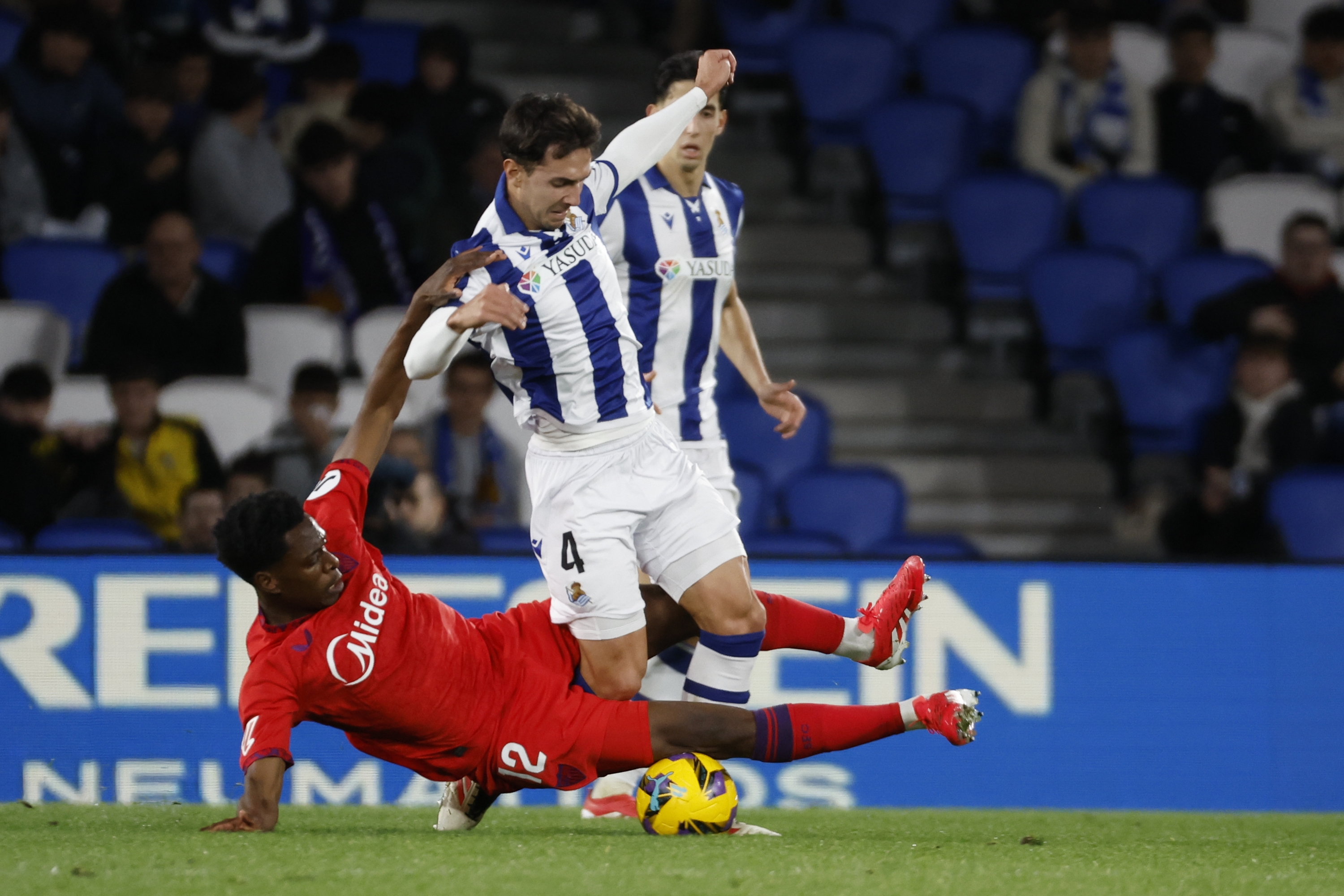 Sevillako jokalari bat Martin Zubimendiri sarrera bat egiten, aurreko jardunaldian. JAVIER ETXEZARRETA / EFE