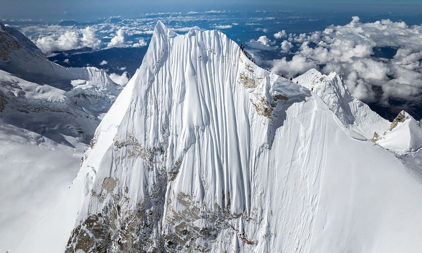 Manaslu mendiko gailurra (8.163 metro), eta eskuinaldean Alex Txikonen espedizioa, banan-bana, bata bestearen atzetik. JACKSON GROVES.