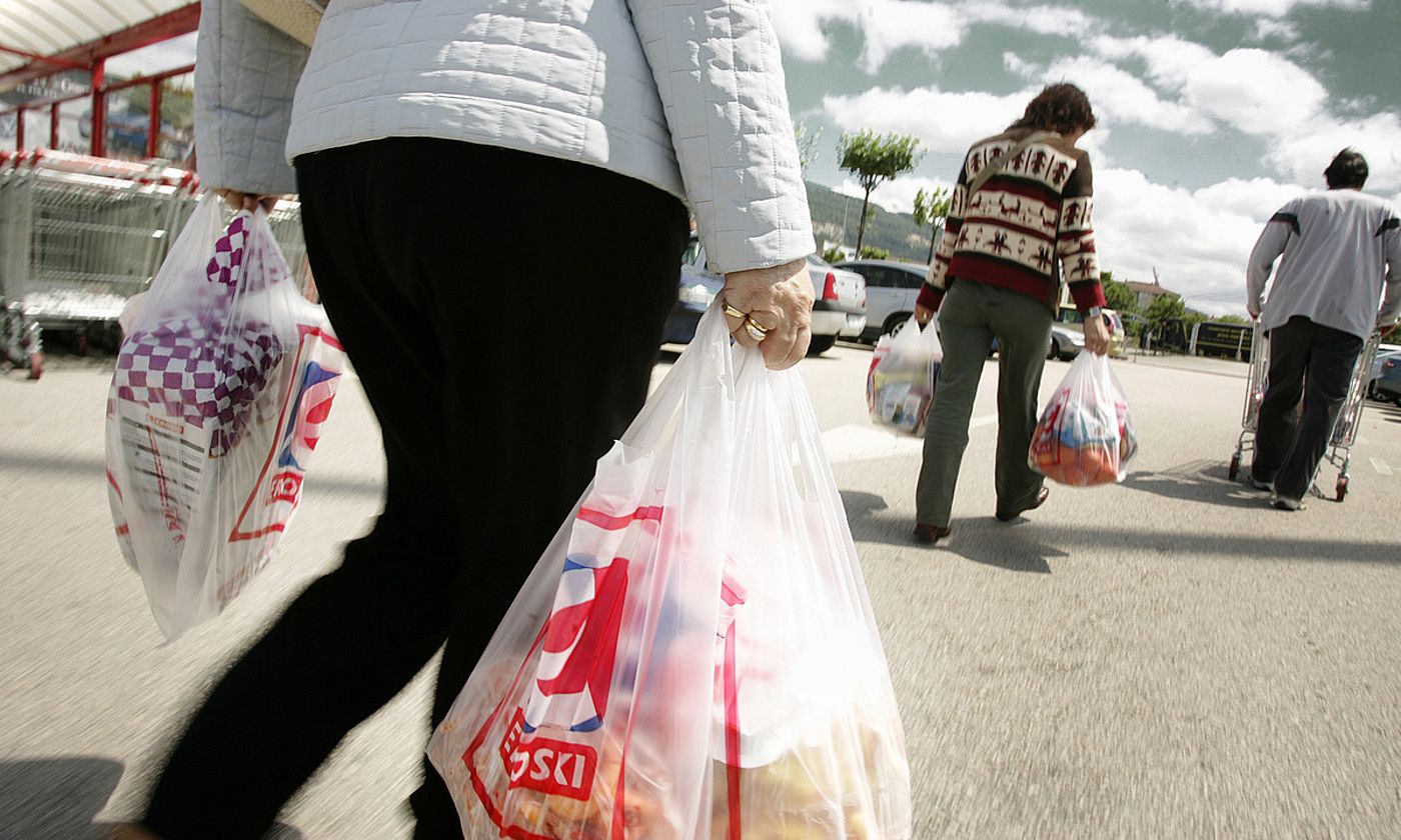 Bezeroak, plastikozko poltsekin supermerkatu batetik irteten. IÑIGO URIZ / FOKU.