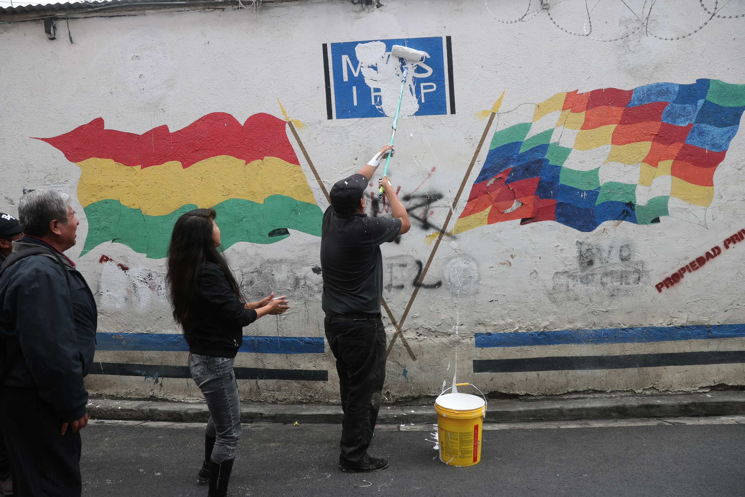 Moralesen jarraitzaile batzuk La Paz hiriburuan martxoaren 10ean, MASen egoitza nagusia margotzen. LUIS GANDARILLAS / EFE