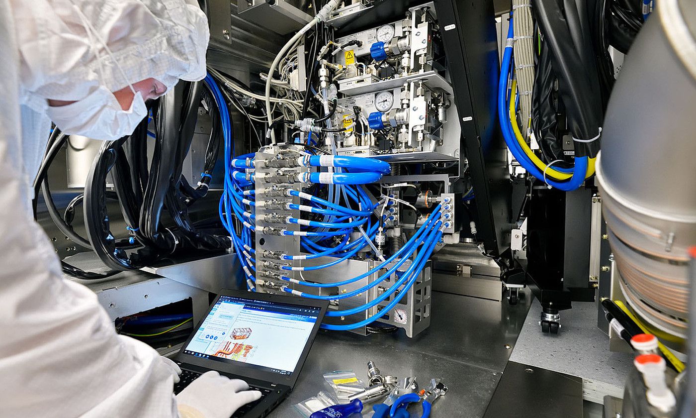 ASML enpresako langile bat, txipak egiteko makina batean. ASML. ASML enpresako langile bat, txipak egiteko makina batean. ASML.