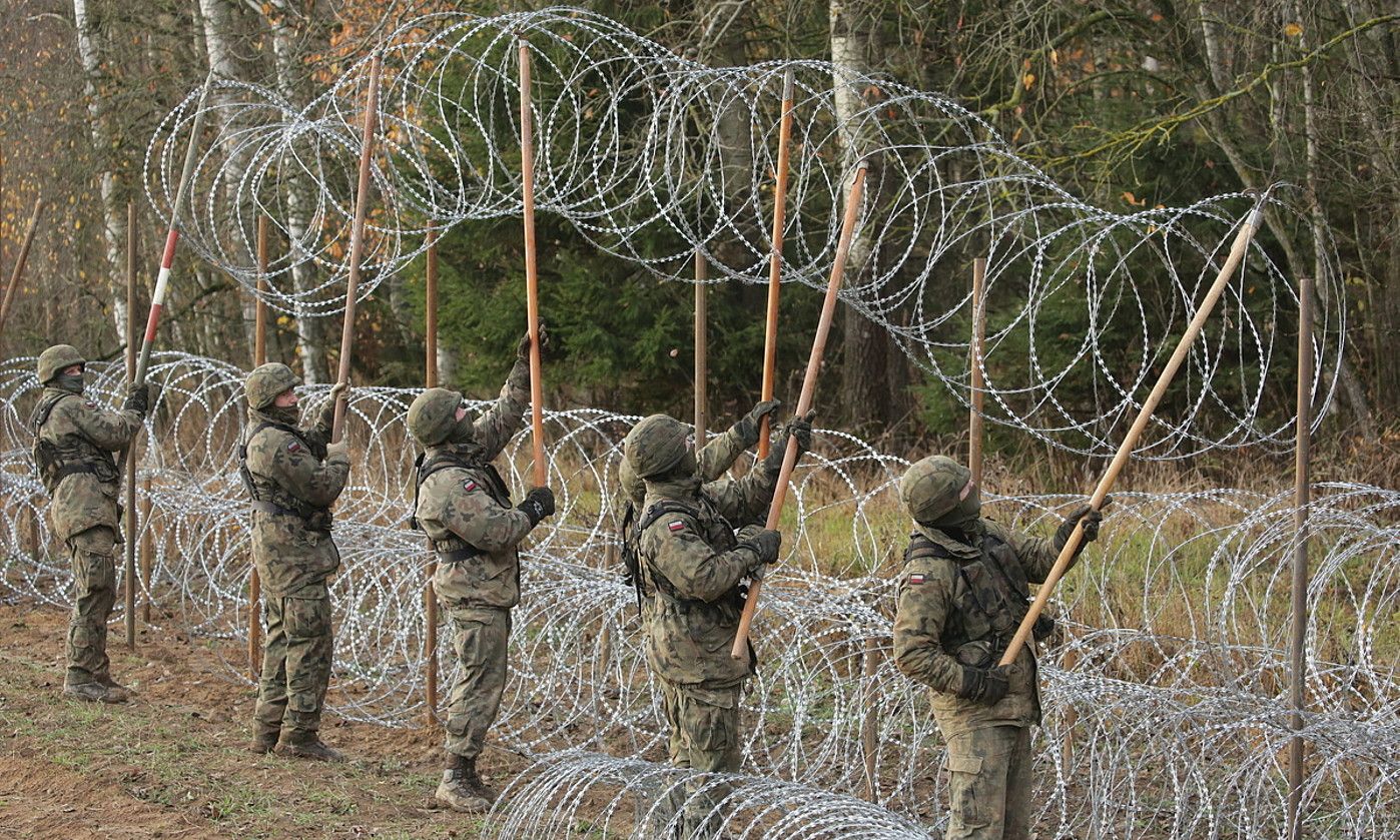 Poloniako soldaduak herrialdeko mugan, labanadun hesia jartzen. T. WSZCZUK / EFE.