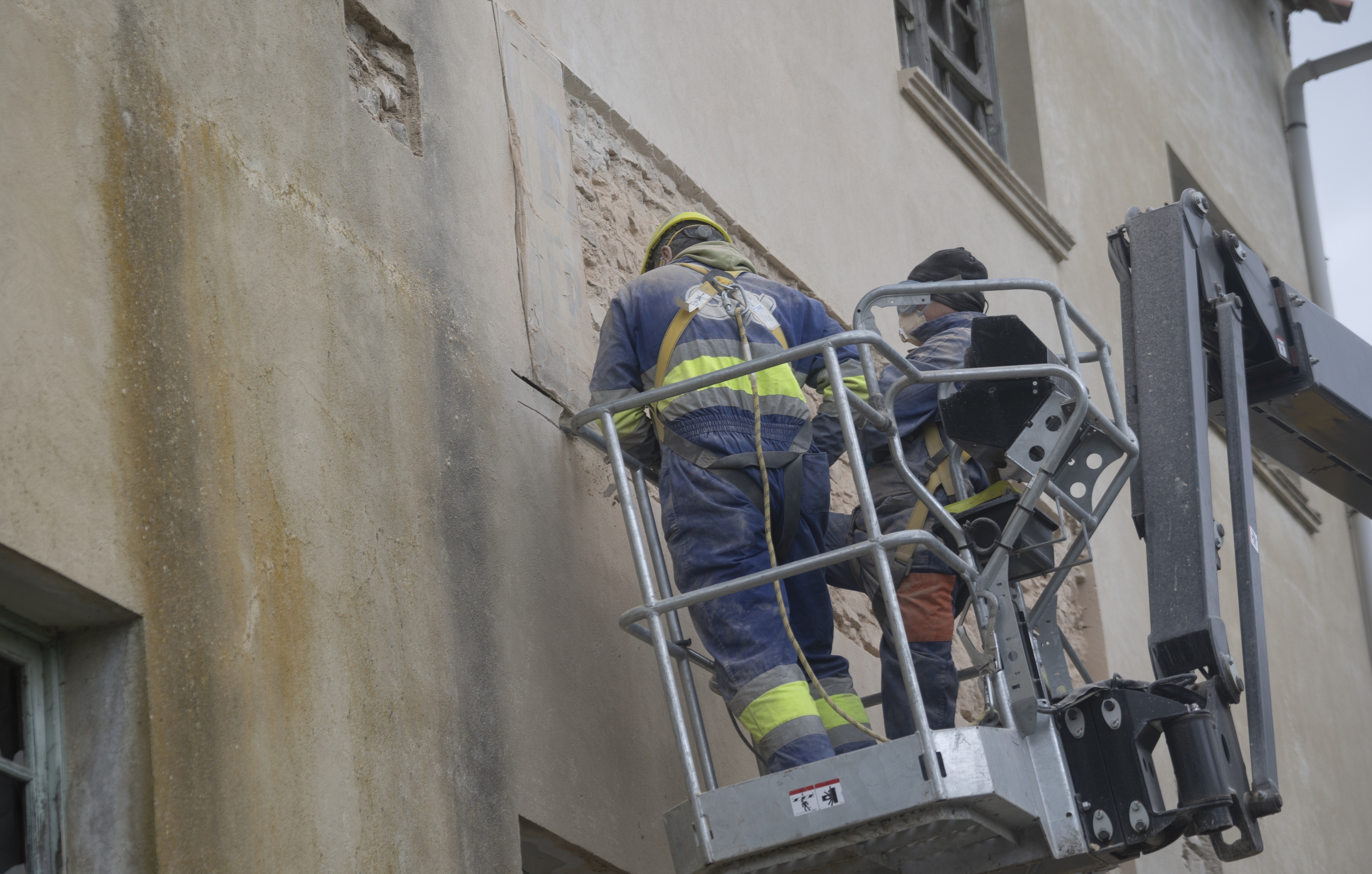 Mariezkurrena etxeko bi langile, martxoaren 27an, Etxauriko irin fabrikako zeramikazko errotulua kentzeko lanak amaitzen. JAGOBA MANTEROLA / FOKUo lanak