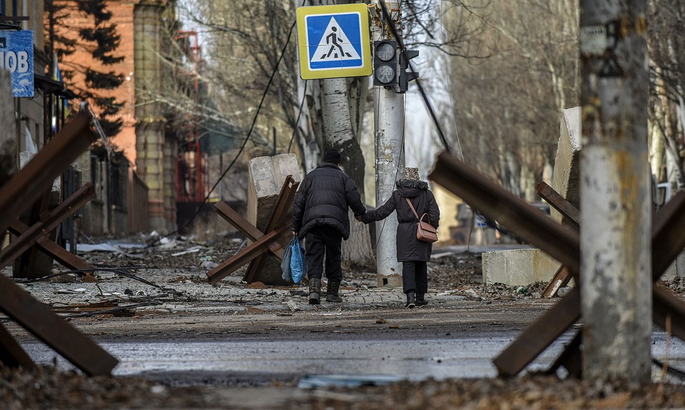 Bi pertsona oinez, urtarrilaren 20an, Bakhmuten (Ukraina), bonbek txikitutako kale batean. OLEG PETRASIUK / EFE.