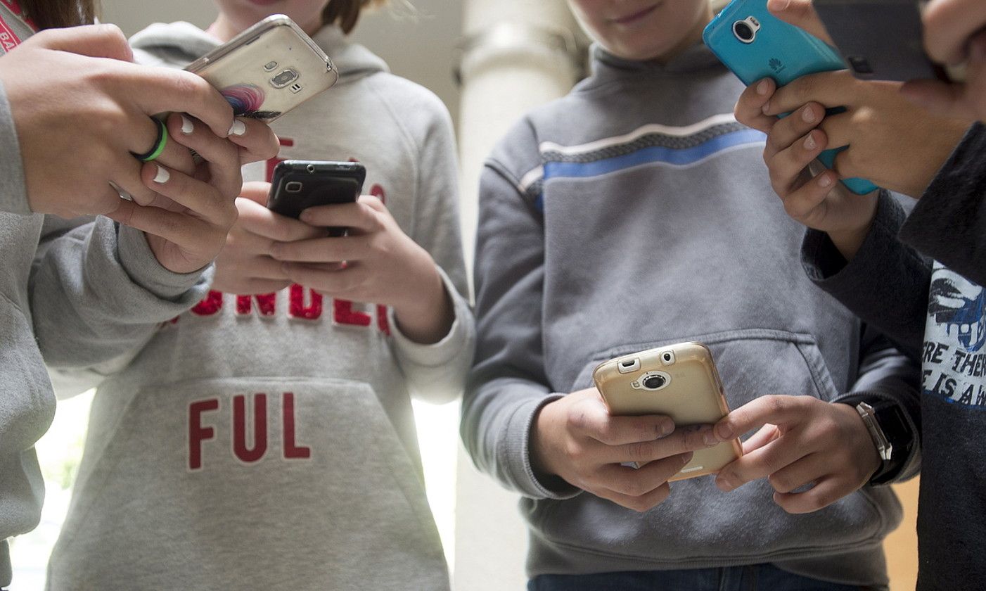 Gazte batzuk, sakelako telefonoa erabiltzen. IÑIGO URIZ / FOKU. Gazte batzuk, sakelako telefonoa erabiltzen. IÑIGO URIZ / FOKU.