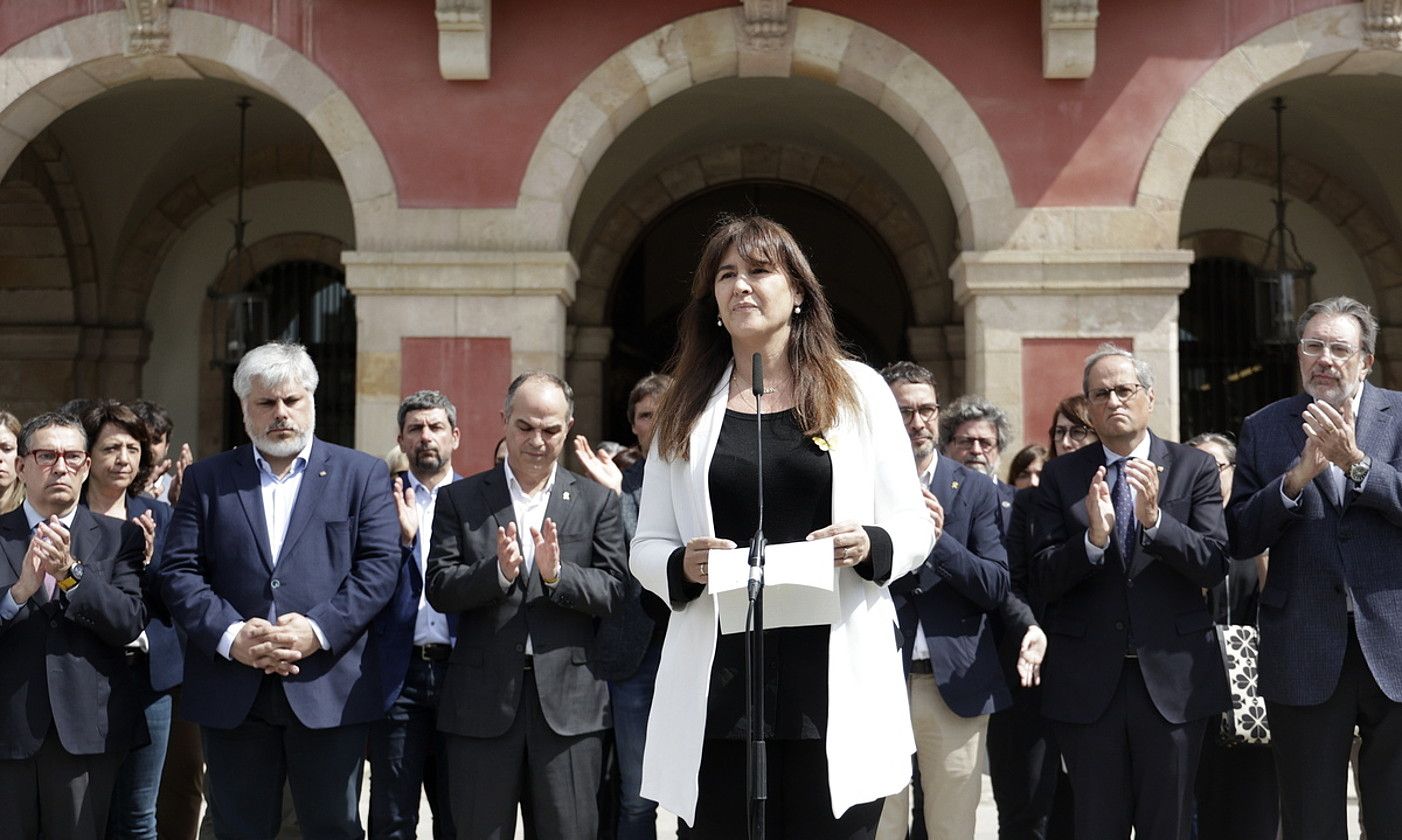 Laura Borras JxCren presidentea, atzo, Kataluniako Parlamentuaren aurrean, atzean alderdikide batzuk dituela. QUIQUE GARCIA / EFE.