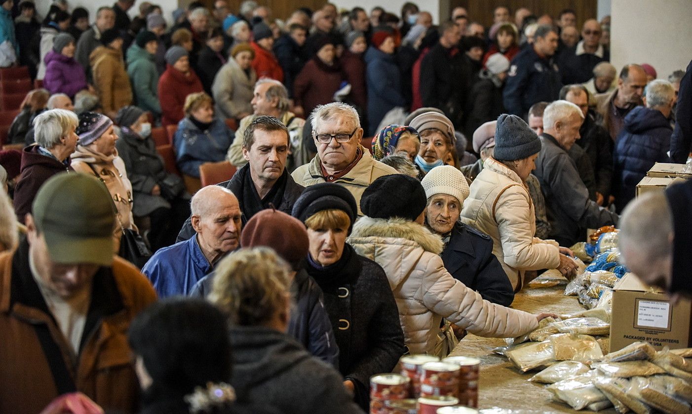 Donetsk eskualdeko Kramatorsk hiriko herritar talde bat laguntza humanitarioa jasotzen, aurreko igandean, eliza batean. OLEG PETRASIUK / EFE.