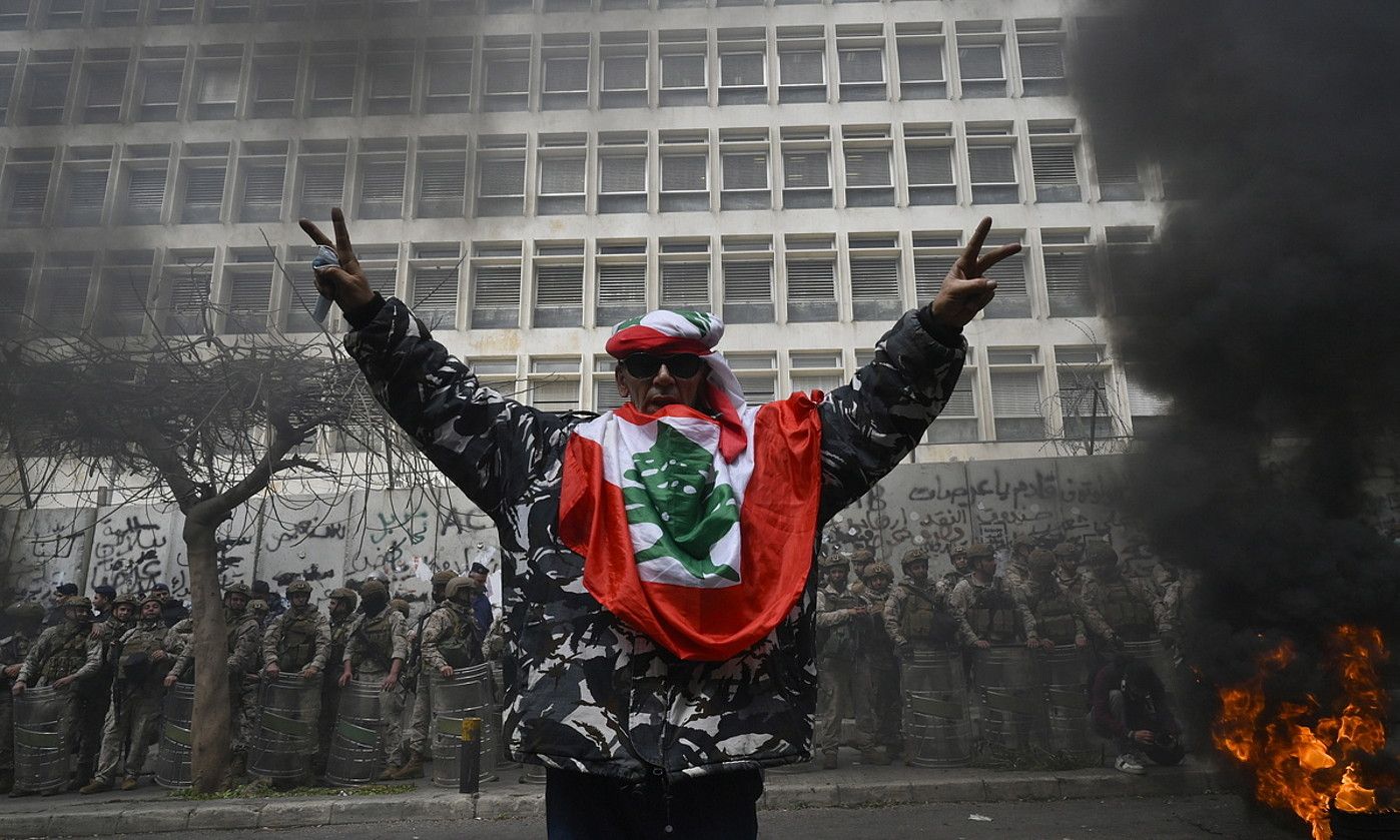 Segurtasun indarretako kide ohi batgaraipen keinua egiten, martxo amaierako protestetan. WAEL HAMZEH / EFE. Segurtasun indarretako kide ohi batgaraipen keinua egiten, martxo amaierako protestetan. WAEL HAMZEH / EFE.