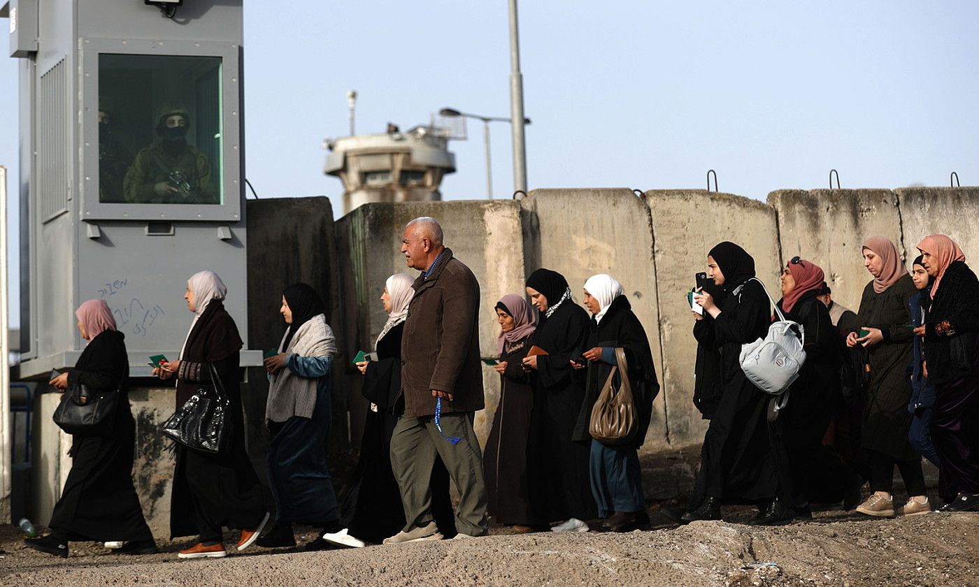 Kontrolak. Palestinar talde bat, Zisjordaniako eremu batetik bestera igarotzeko ilara egiten. ATEF SAFADI / EFE.