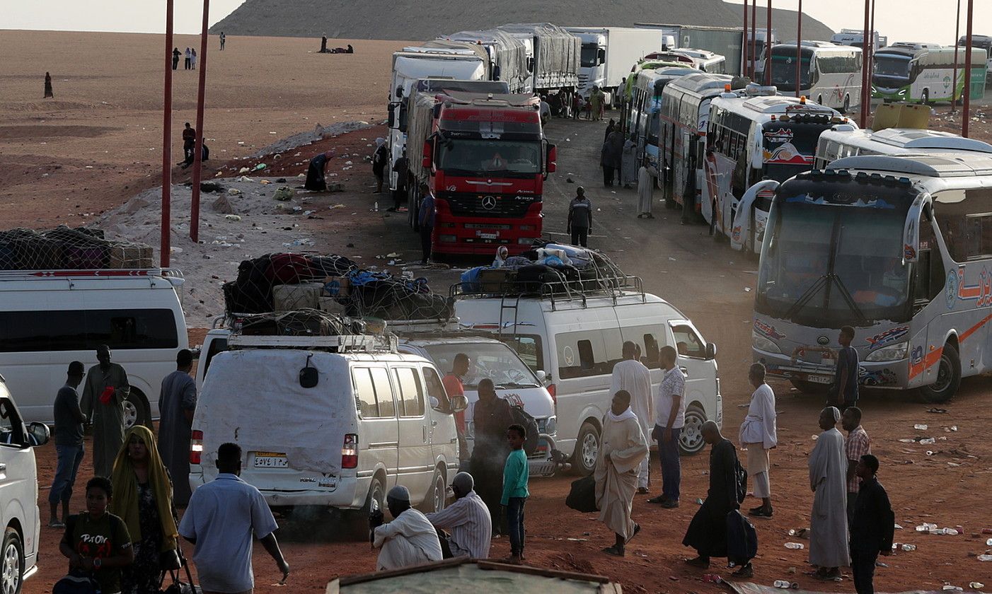 Sudango iheslariak autobusa hartzeko zain, Sudanen eta Egiptoren arteko muga zeharkatu ondoren. KHALED ELFIQI / EFE.