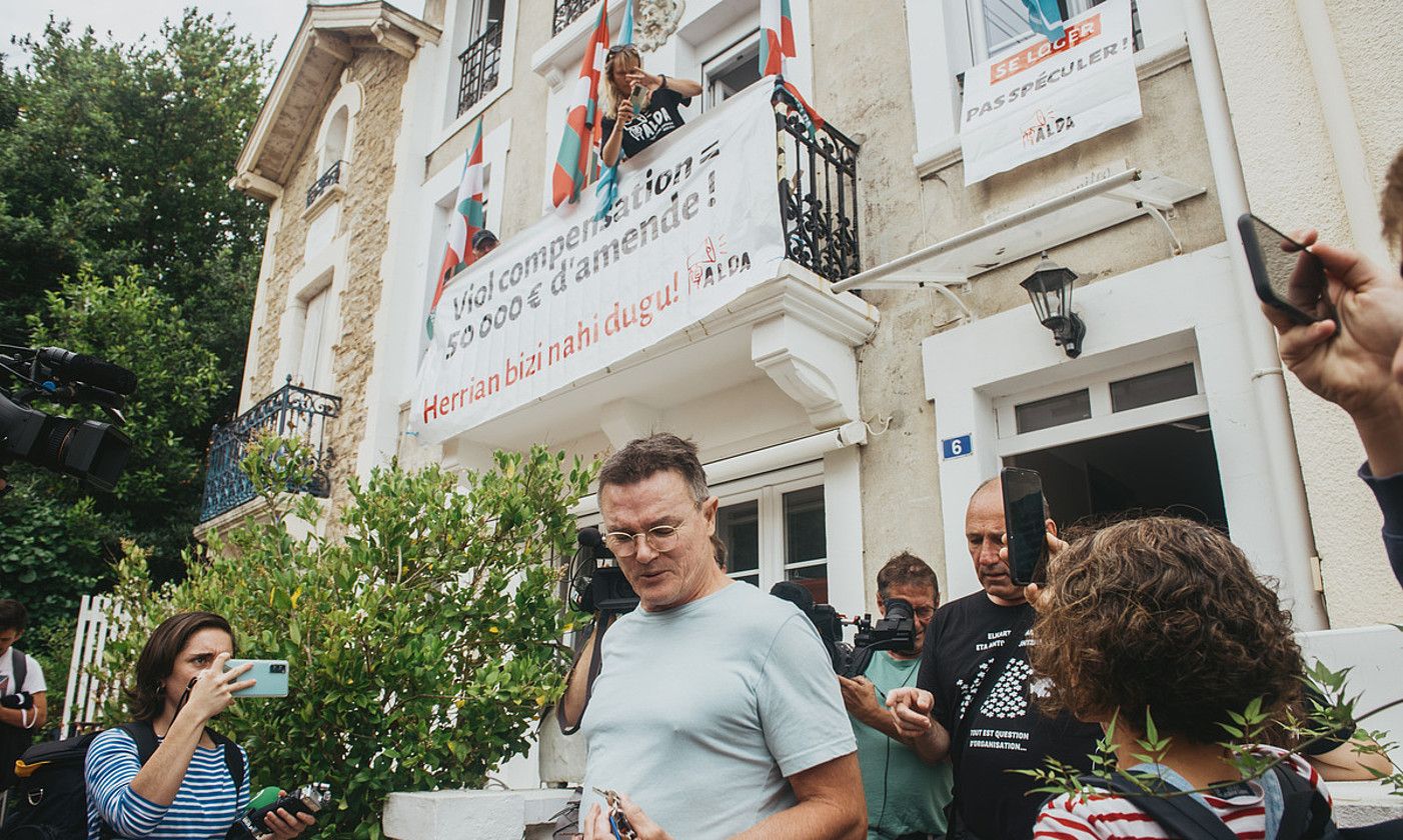 Etxebizitzaren jabea, kazetariez eta Aldako kideez inguratua. GUILLAUME FAVEAU. Etxebizitzaren jabea, kazetariez eta Aldako kideez inguratua. GUILLAUME FAVEAU.