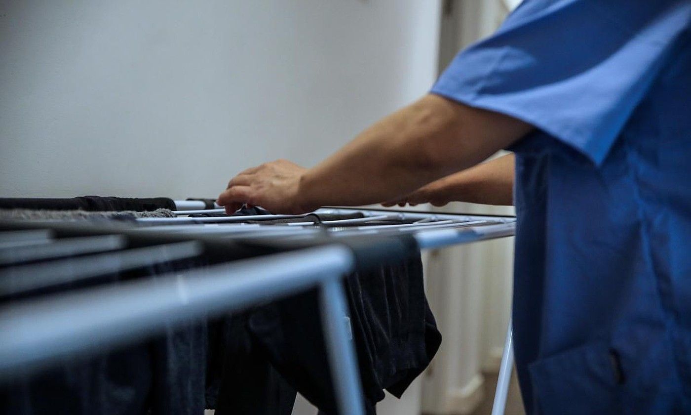 Etxeko langile bat arropa eskegitzen. DANI CABALLO / EFE