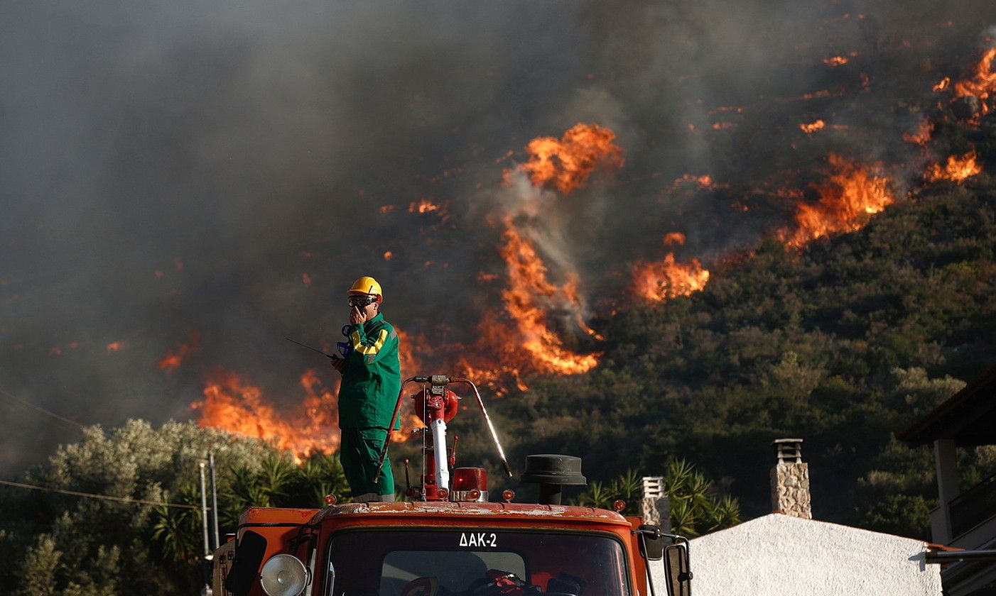 Suhiltzaile bat, lanean, suteek kiskalitako eremutik gertu, herenegun, Attican (Grezia). YANNIS KOLESIDIS / EFE.