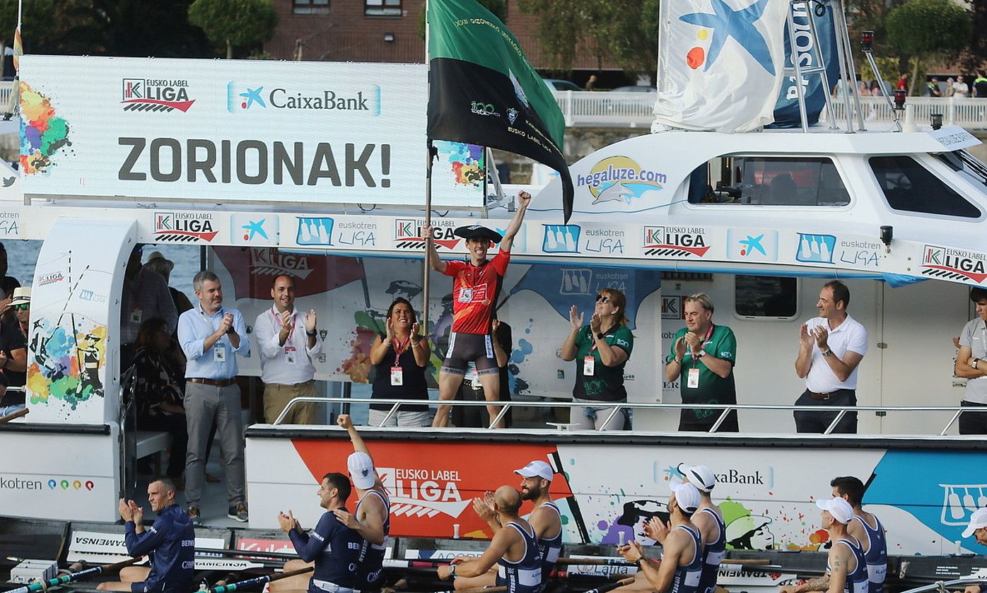 Gorka Aranberri Urdaibaiko patroia atzo lortutako bandera astintzen, taldekideek txalo jotzen dioten bitartean. OSKAR MATXIN EDESA / FOKU.