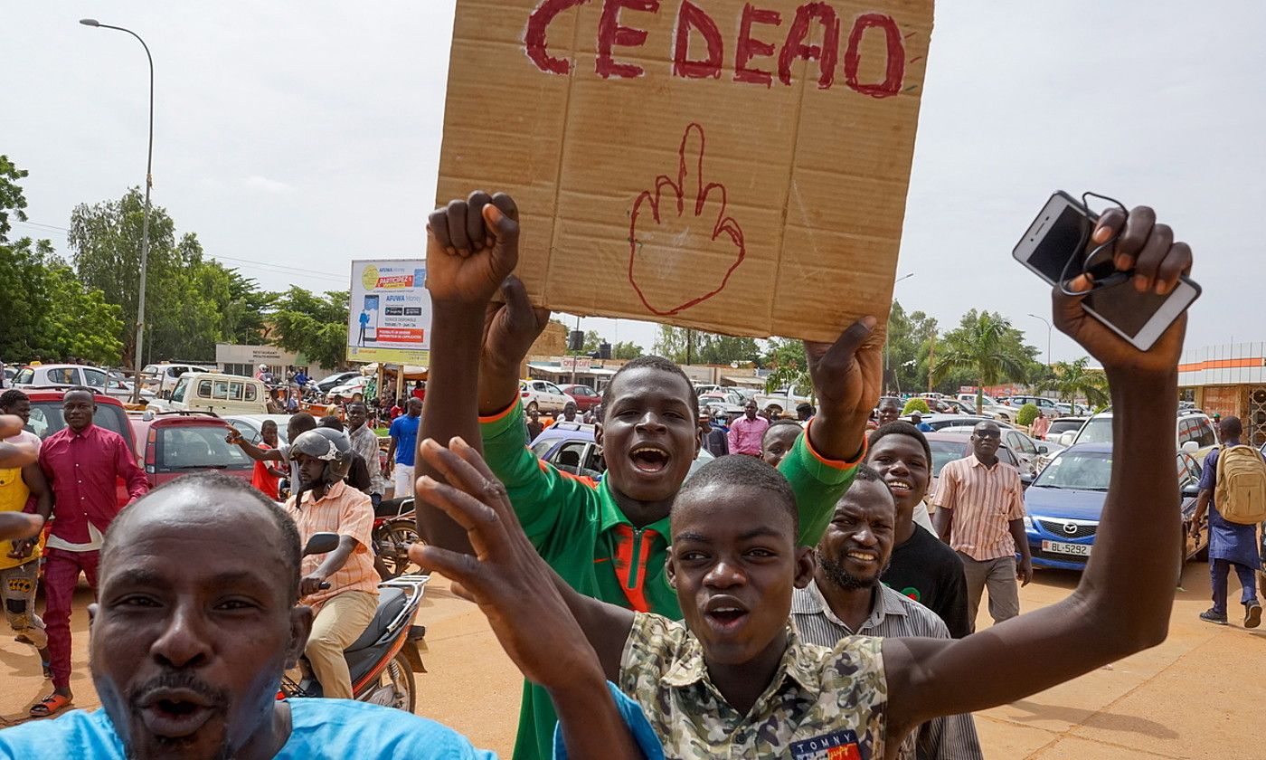 Nigerko junta militarraren aldeko manifestariak, igandean, Niamein, Ecowasen aurkako pankarta batekin. ISSFOU DJIBO / EFE.