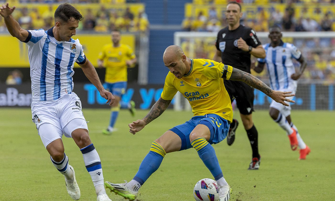 Realeko Martin Zubimendi eta Las Palmaseko Sandro Ramirez, atzo, baloia eskuratzeko lehian. QUIQUE CURBELO / EFE. Realeko Martin Zubimendi eta Las Palmaseko Sandro Ramirez, atzo, baloia eskuratzeko lehian. QUIQUE CURBELO / EFE.