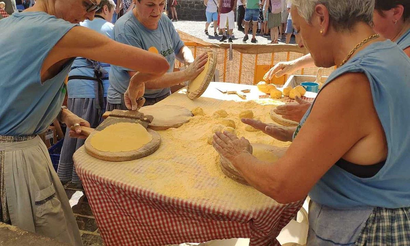 Herriko emakume batzuk, taloak egiten, aurreko ekitaldi batean. BERRIA.