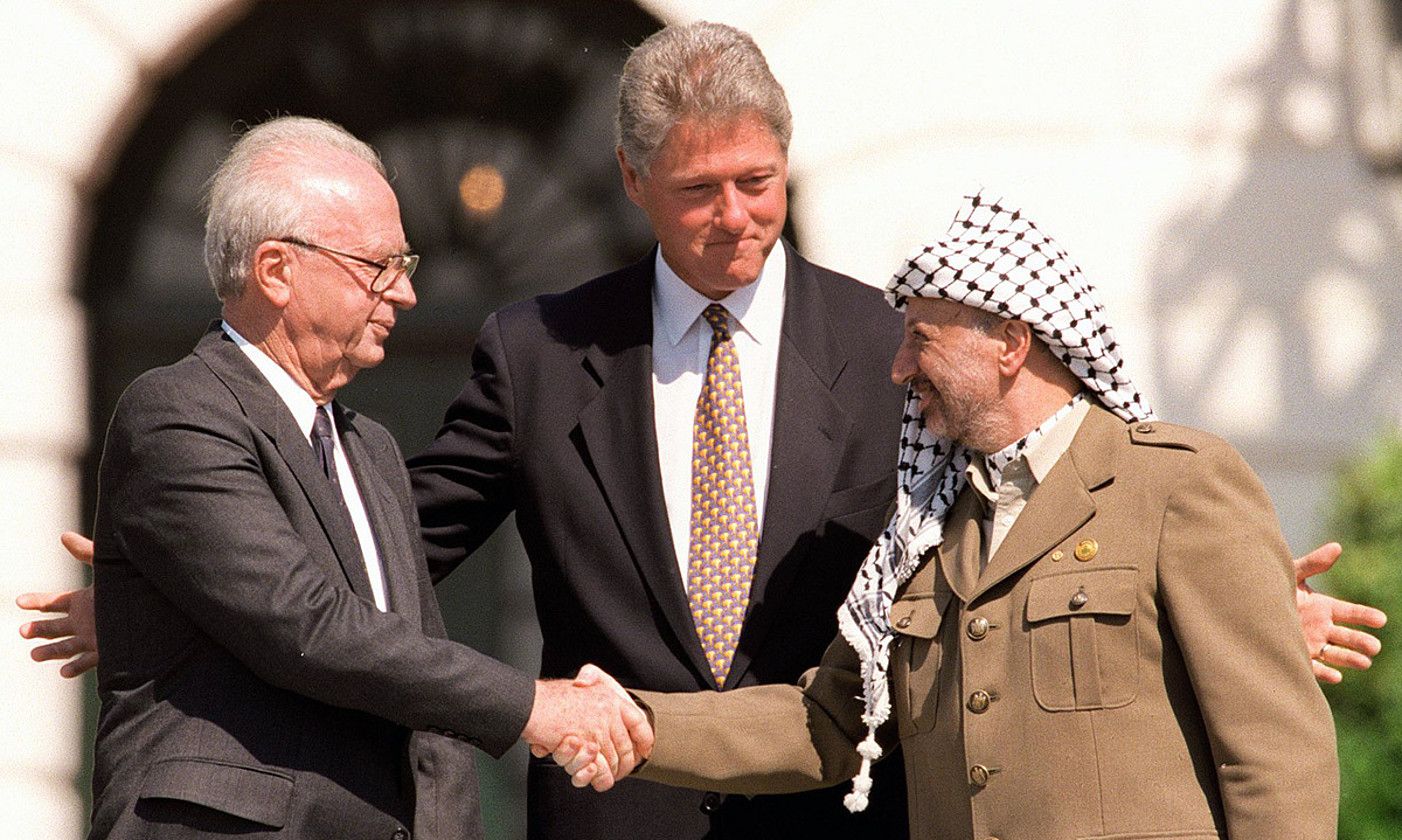 Bosteko historikoa. Yitzhak Rabin eta Yasser Arafat, Israelgo orduko lehen ministroa eta Palestina Askatzeko Erakundeko burua, hurrenez hurren, elkarri eskua ematen. J. DAVID AKE / EFE. Bosteko historikoa. Yitzhak Rabin eta Yasser Arafat, Israelgo orduko lehen ministroa eta Palestina Askatzeko Erakundeko burua, hurrenez hurren, elkarri eskua ematen. J. DAVID AKE / EFE.
