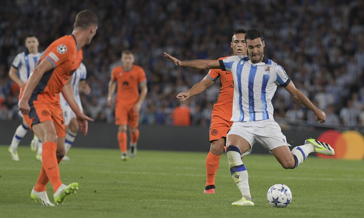 Mikel Merino Realeko jokalaria, baloia astintzear, Inter Milaneko bi jokalariren artean, atzo, Txapeldunen Ligako lehen partidan, Anoetan. JON URBE / FOKU.