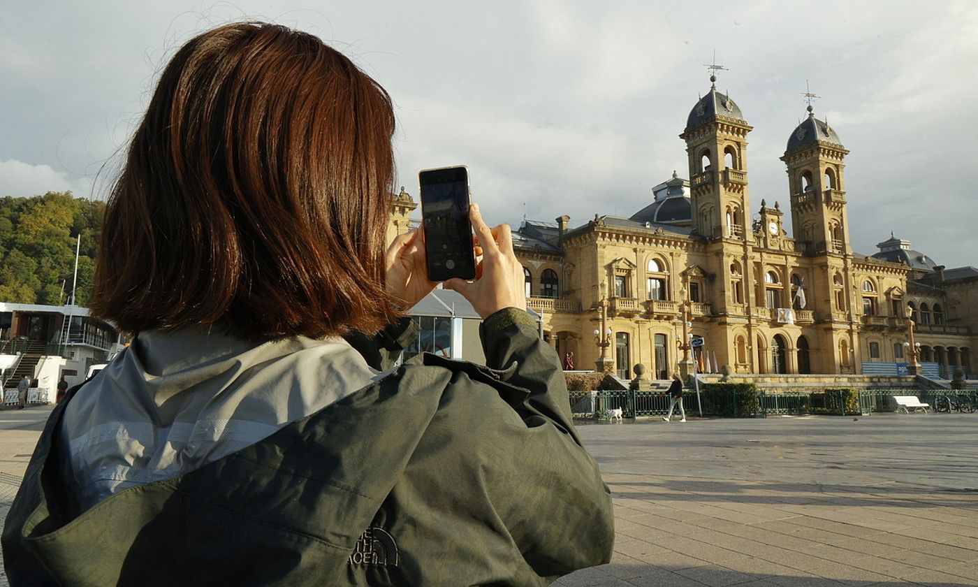 Turista bat, Donostiako udaletxearen aurrean. MAIALEN ANDRES / FOKU.