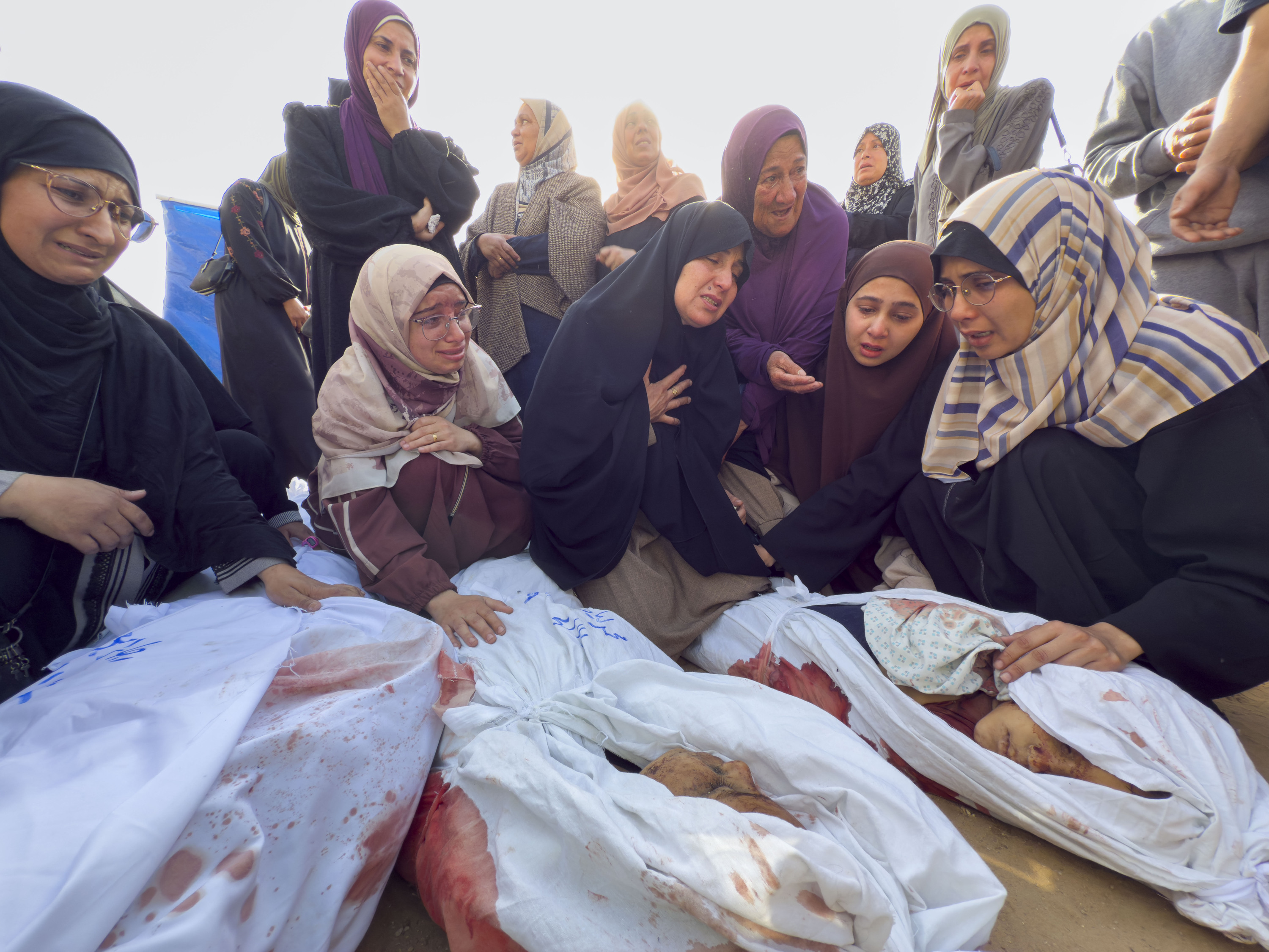 Emakume batzuk atzo Gazan, gorpu batzuen aurrean. AHMAD AWAD / EFE