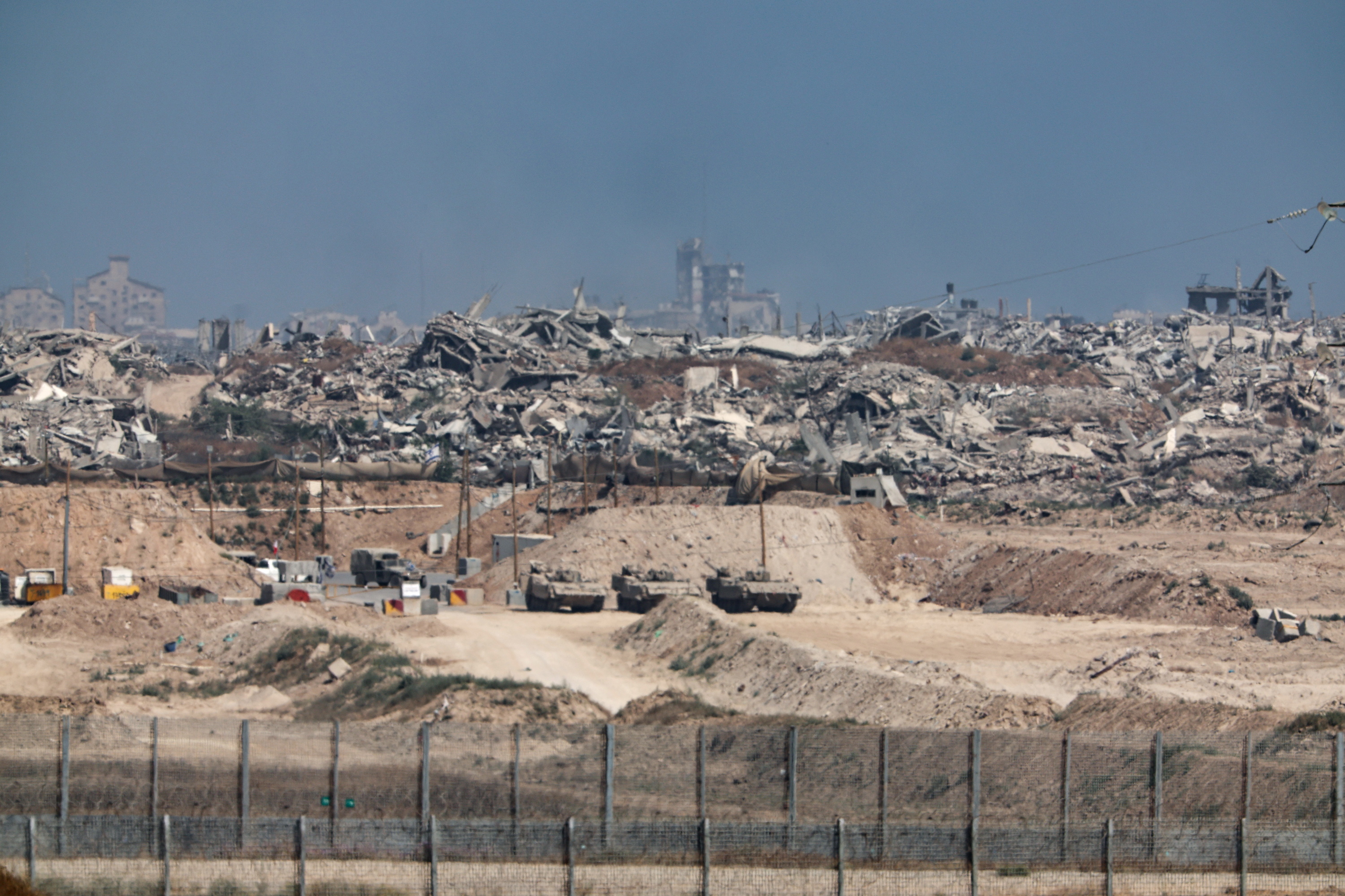 Israelgo armada Gazara sartzen, gaur. Atzean, erasoek suntsitutako eraikinak. ATEF SAFADI / EFE