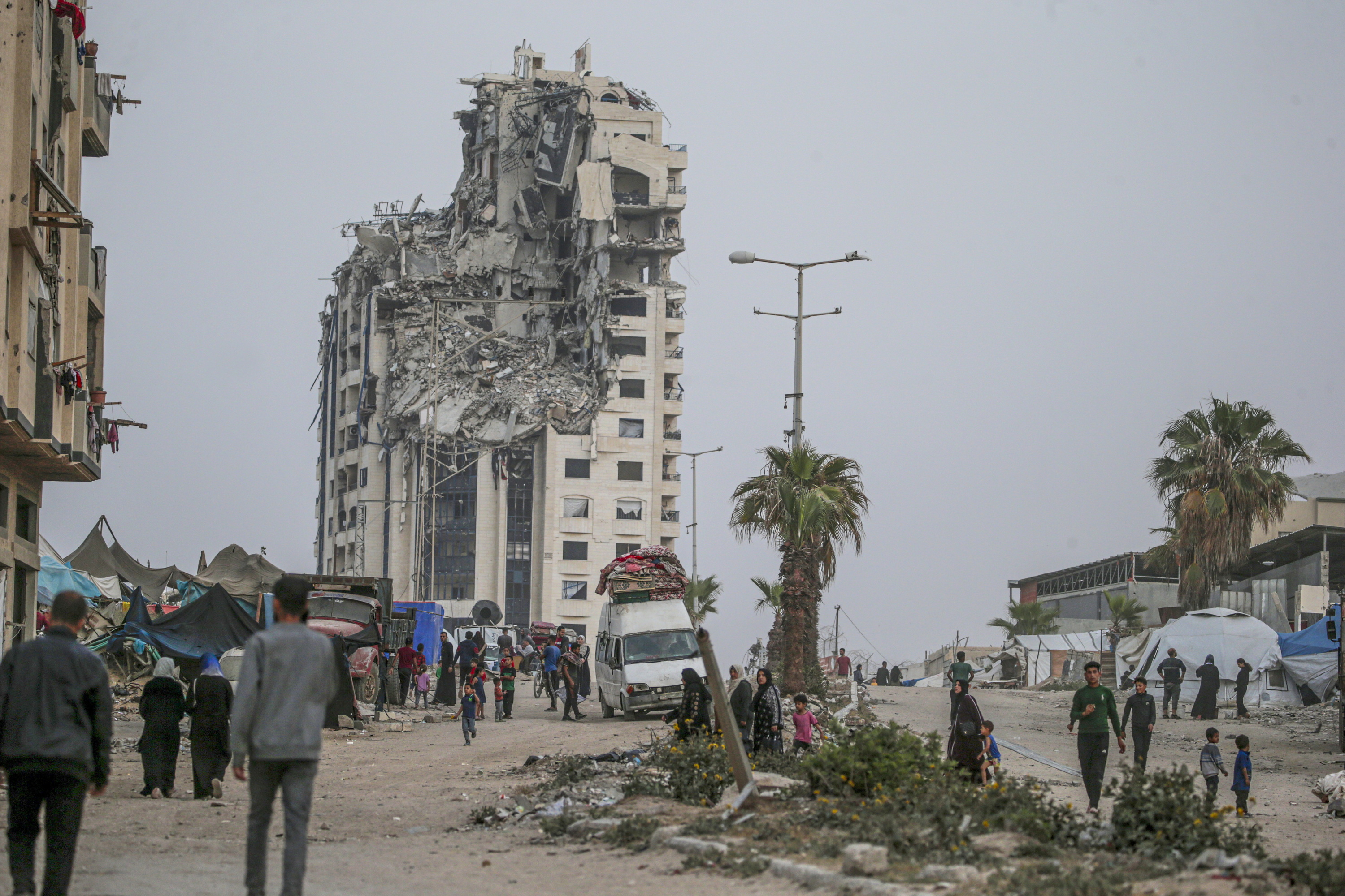 Palestinarrak suntsitutako eraikinen artean atzo, Gaza hirian. MOHAMMED SABER / EFE
