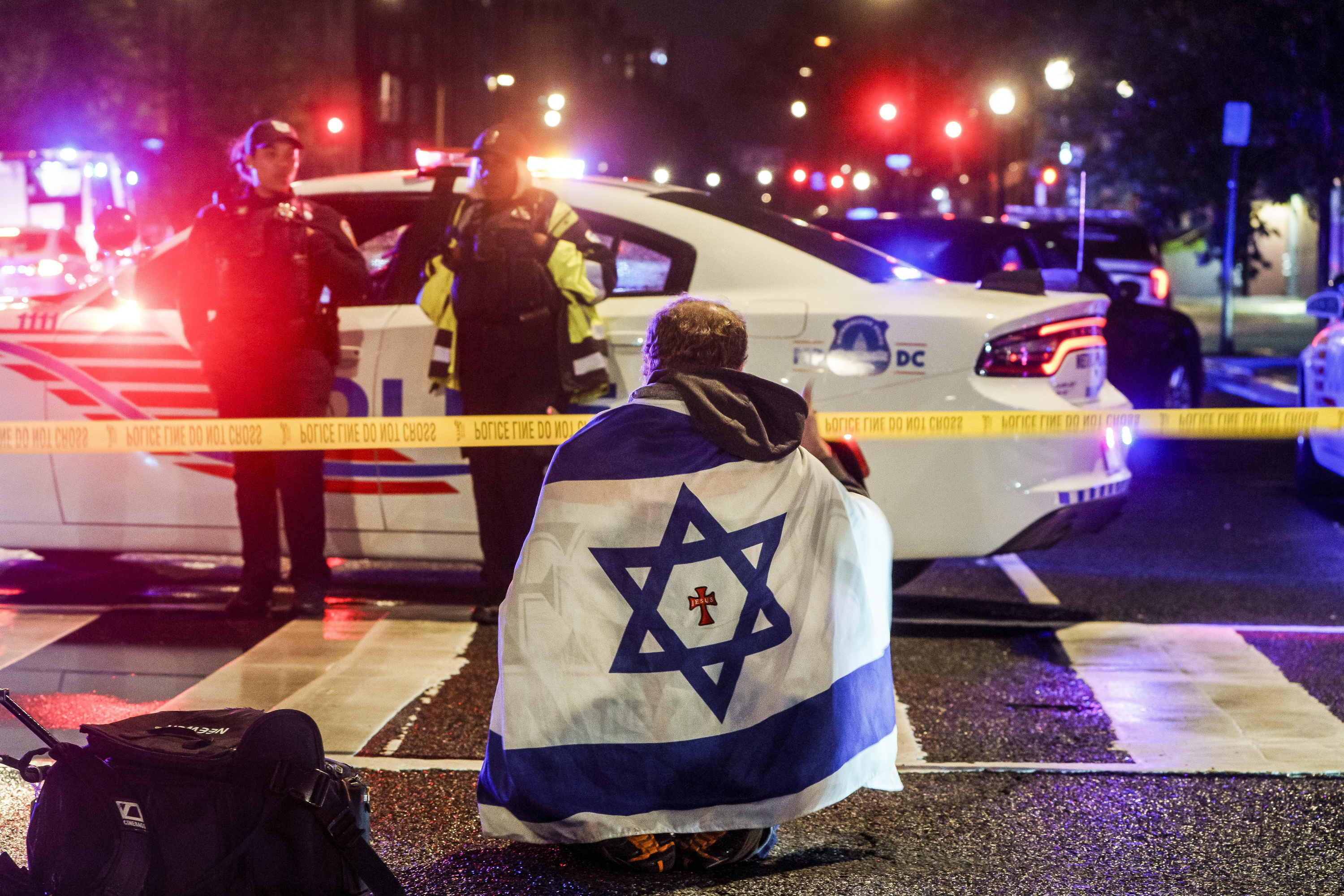 Pertsona bat Israelgo bandera bat bizkarrean duela, gaur goizaldean tiroketa izan den gunetik hurbil, Washingtonen. WILL OLIVER / EFE