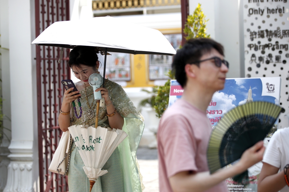 Turista bat, beroaren aurka borrokan, Thailandian, 2024ko udan. RUNGROJ YONGRIT / EFE Turista bat, beroaren aurka borrokan, Thailandian, 2024ko udan. RUNGROJ YONGRIT / EFE